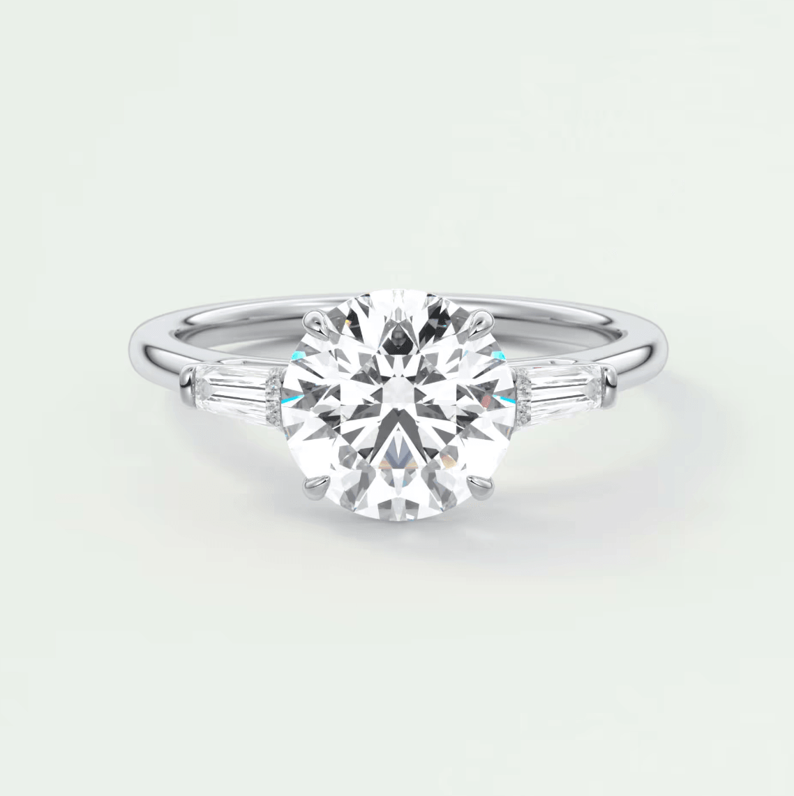 18k white gold engagement ring with a round diamond center and baguette diamonds on the band.