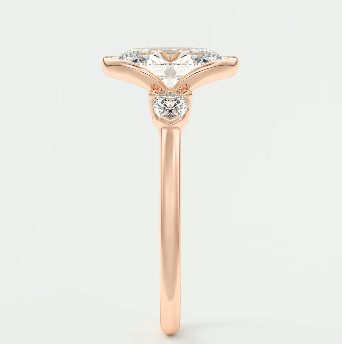 18k rose gold engagement ring with marquise-cut diamond and small round diamonds on band.