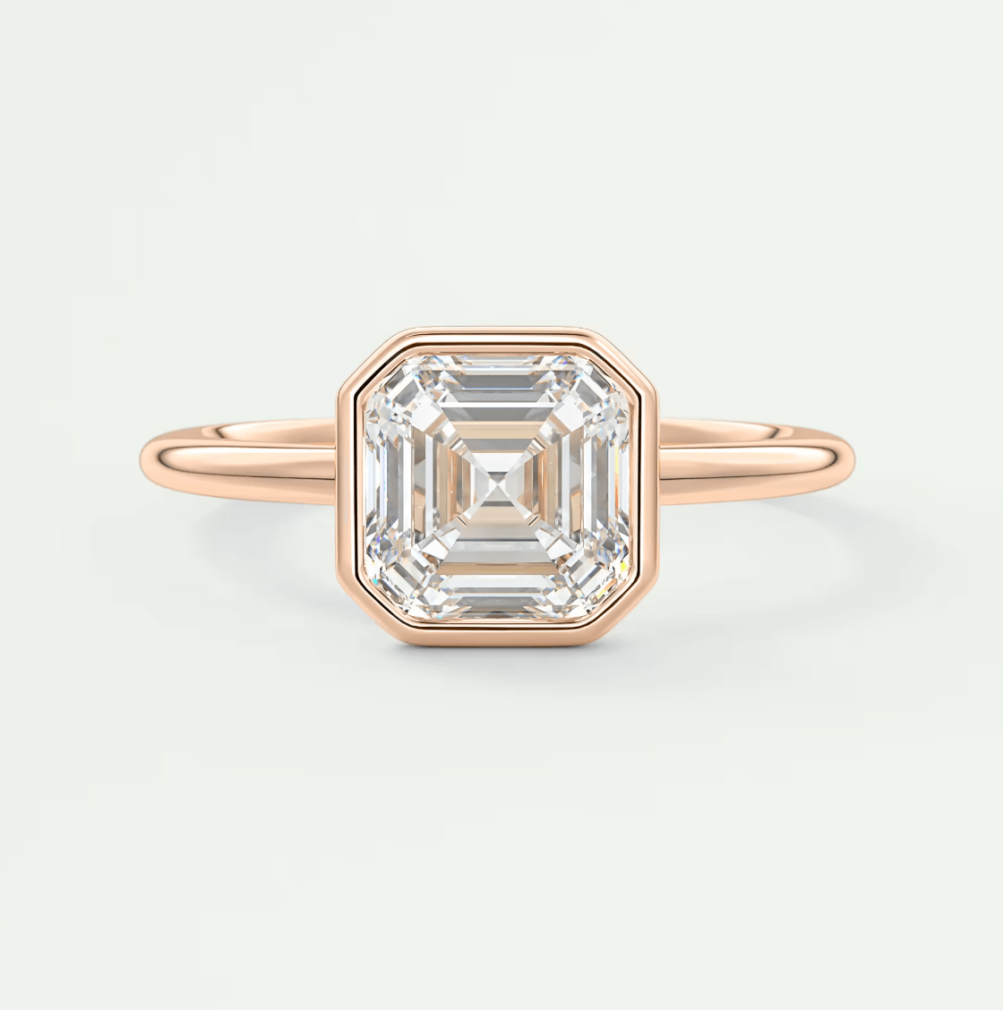 18k rose gold emerald cut diamond ring with a bezel setting.
