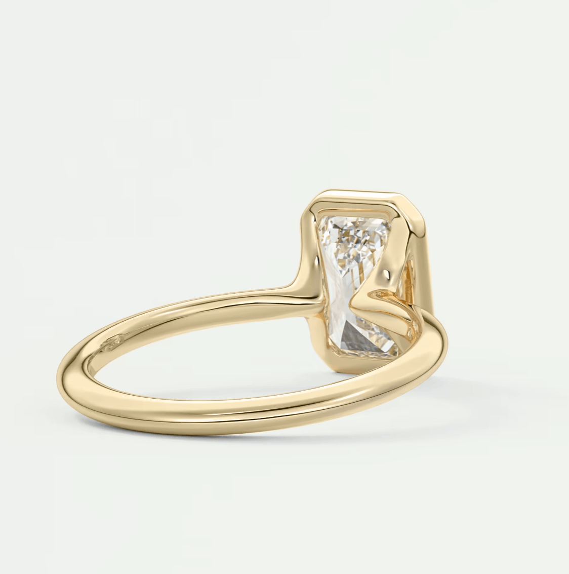 18k yellow gold engagement ring with a baguette-cut diamond.