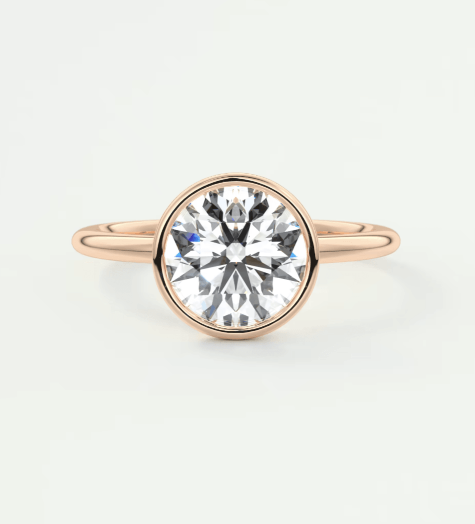Rose gold diamond engagement ring with a bezel setting.