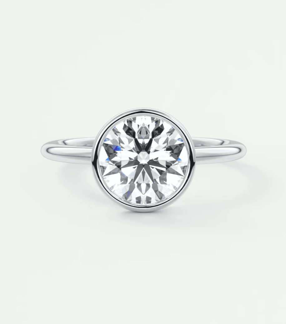 18-karat white gold diamond engagement ring with a bezel setting.
