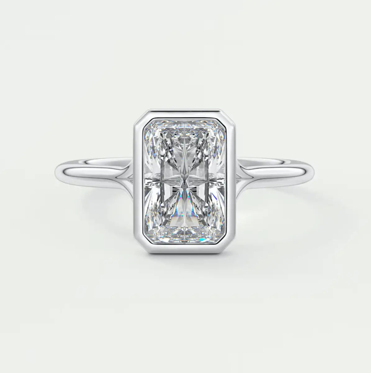 18k white gold emerald cut diamond ring with a bezel setting.