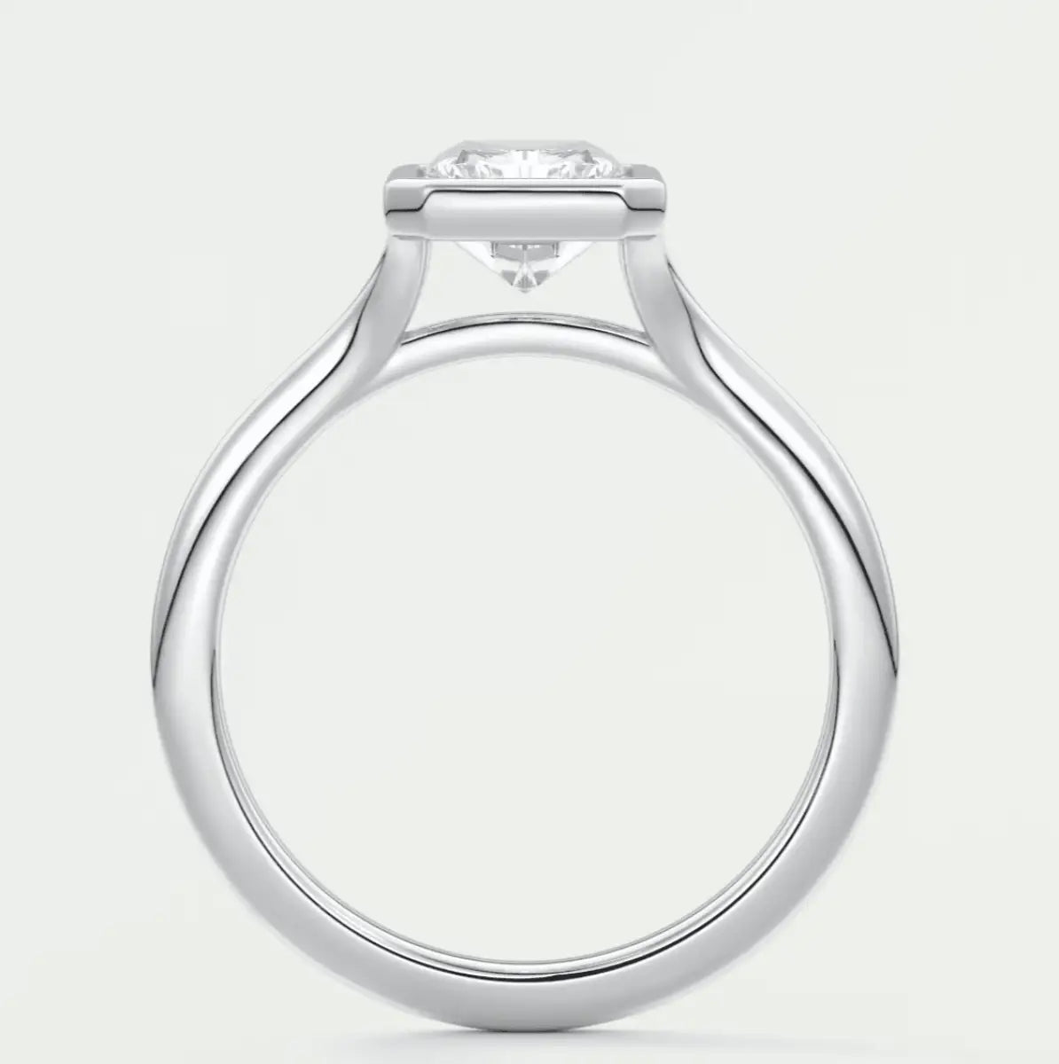 White gold solitaire diamond engagement ring with a cushion-cut center stone.