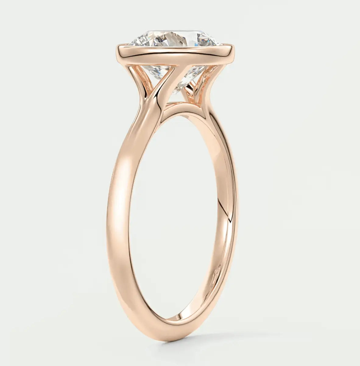 18-karat rose gold engagement ring with a cushion-cut diamond.