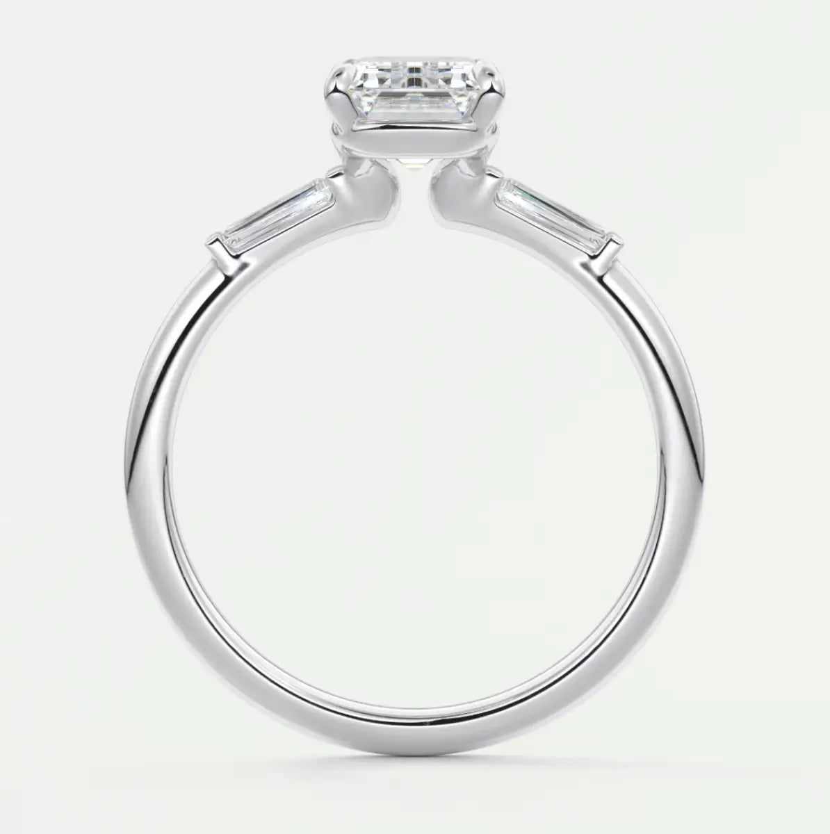 Custom made elysian emerald three-stone engagement ring with tapered baguettes
