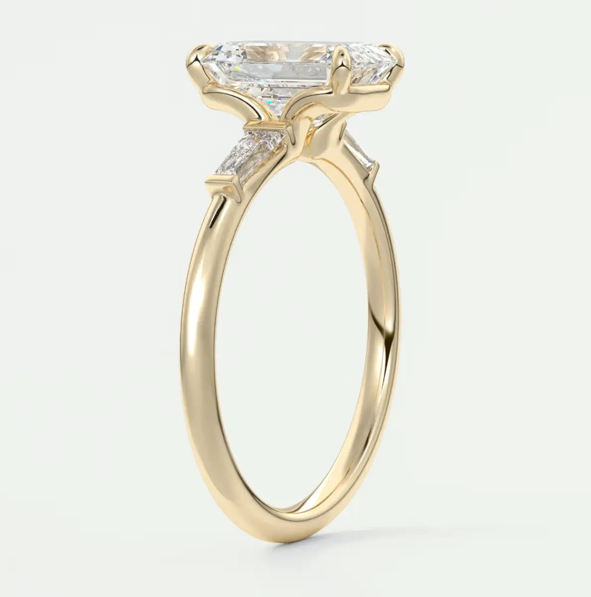 Custom made elysian emerald three-stone engagement ring with tapered baguettes
