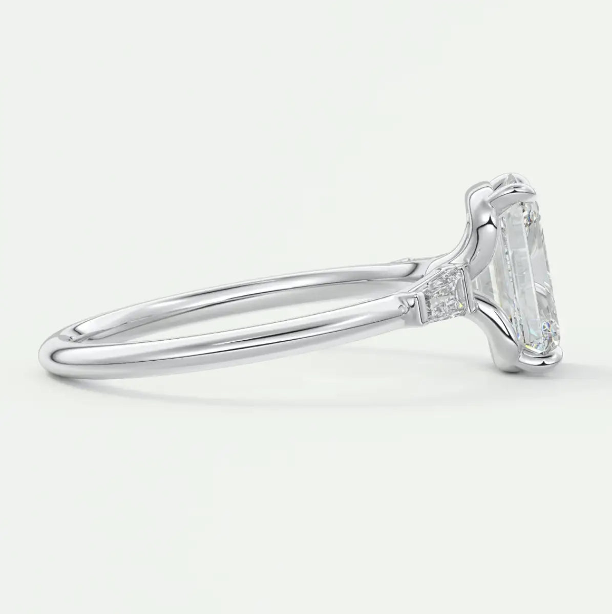 Custom made elysian emerald three-stone engagement ring with tapered baguettes