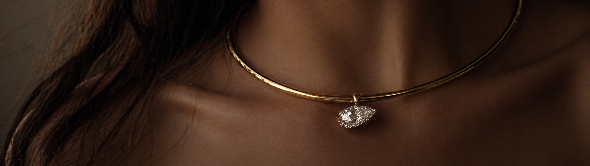 Close-up of a gold necklace with a heart-shaped pendant on a blurred background