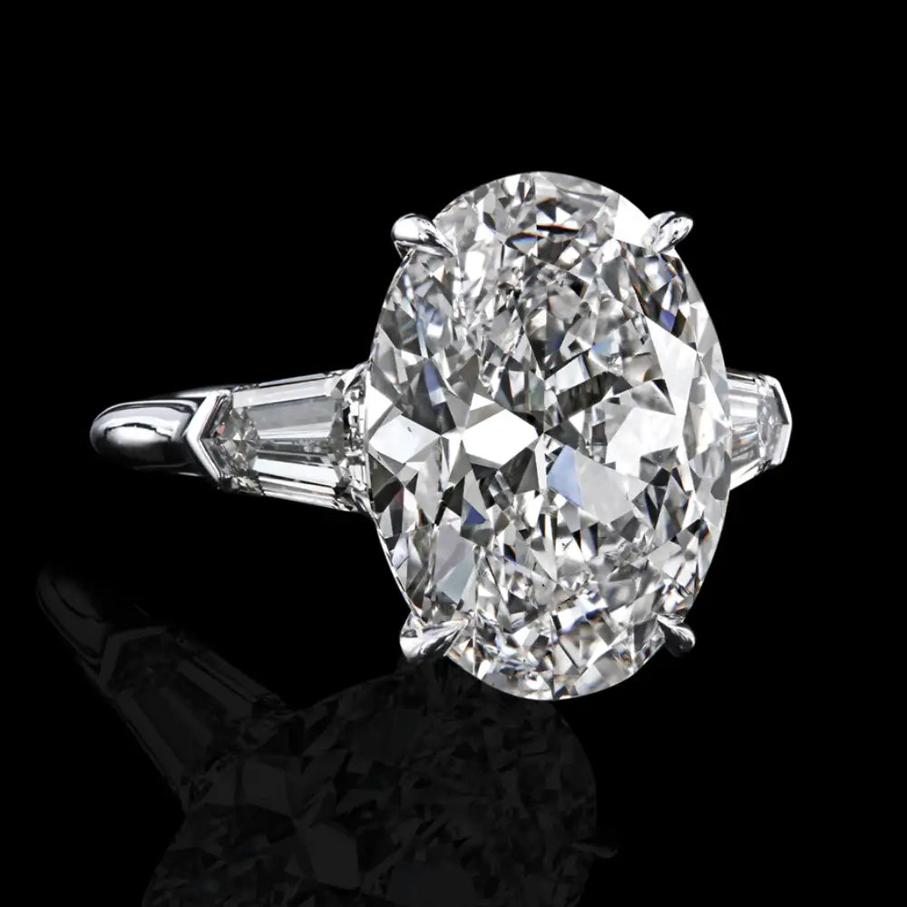 A stunning oval-cut diamond ring set in a sleek platinum band with baguette diamonds on either side.