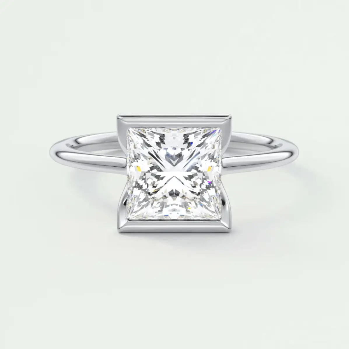 Princess cut diamond engagement ring with white gold band and bezel setting.