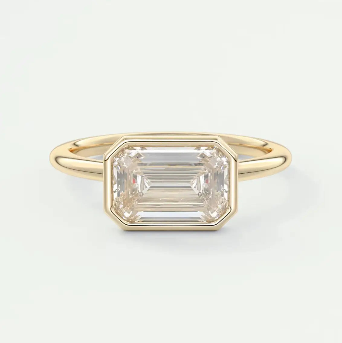 East West Emerald Bezel Engagement Ring