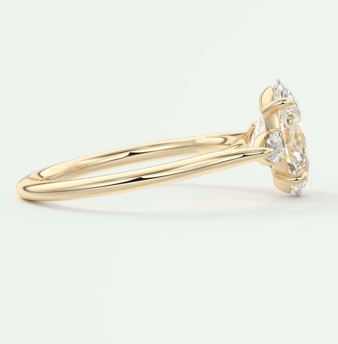 18k yellow gold engagement ring with a marquise-cut diamond and two smaller diamonds on either side.
