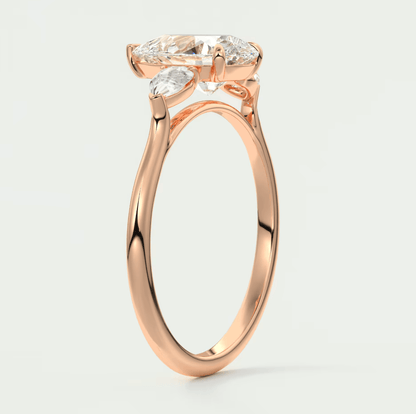 Rose gold engagement ring with three marquise-cut diamonds set in a delicate, modern design.