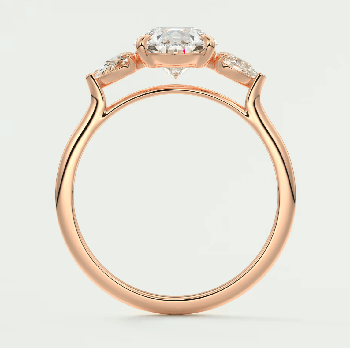 Rose gold engagement ring with a cushion-cut diamond and two smaller diamonds on either side, featuring an elegant design.