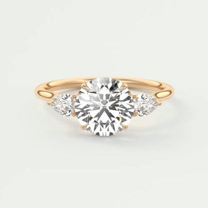 18-karat rose gold engagement ring with a round diamond center and two smaller diamonds on each side.