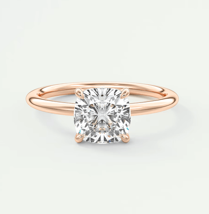 Rose gold cushion-cut diamond engagement ring with four prongs.