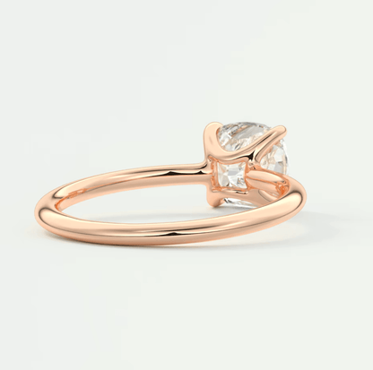 Rose gold engagement ring with a pear-shaped diamond and baguette side stones.