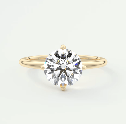18k yellow gold solitaire diamond engagement ring with a round brilliant cut gemstone.