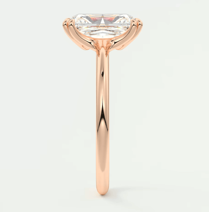 Rose gold engagement ring with a marquise-cut diamond.