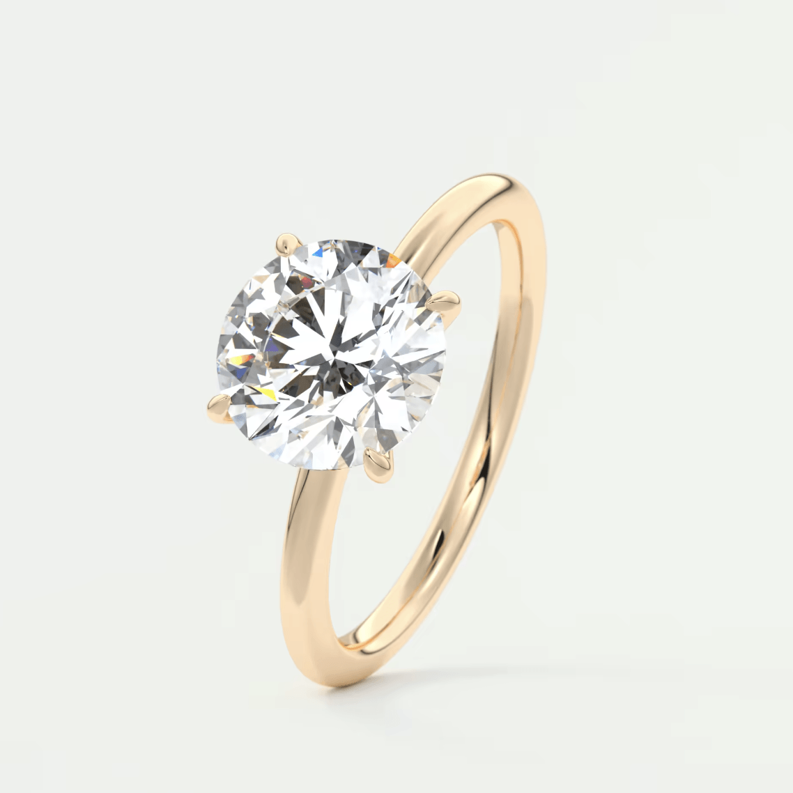 18-karat gold solitaire diamond engagement ring with a round brilliant cut gemstone.