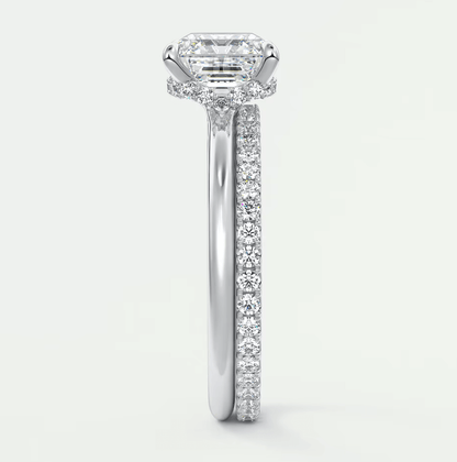 18k white gold diamond engagement ring with an emerald cut center stone and a pave set band.