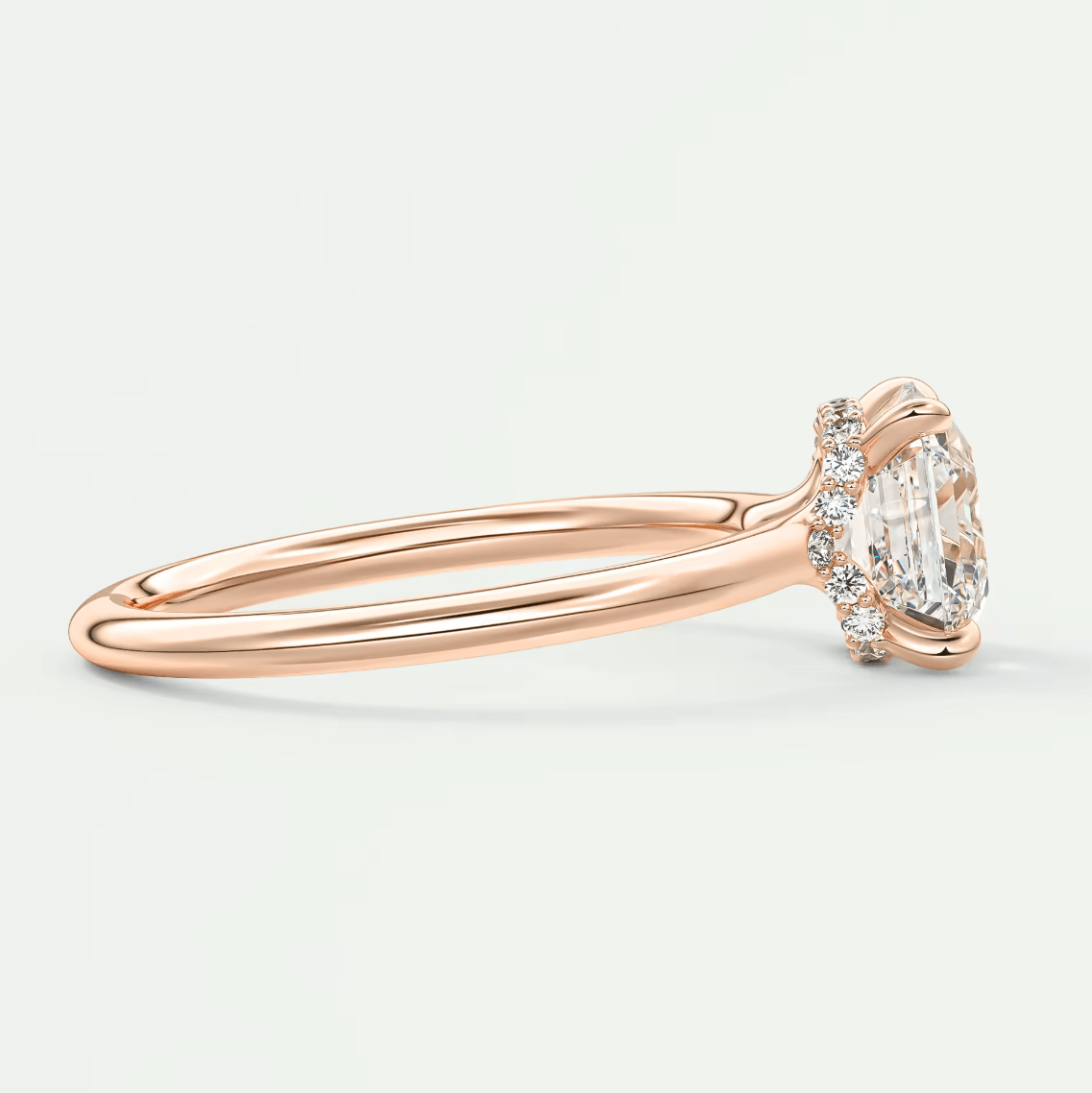 18k rose gold engagement ring with a marquise-cut diamond and small round diamonds on the band.