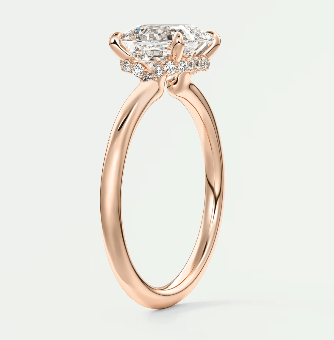 Rose gold marquise diamond engagement ring with halo detailing and side stones.
