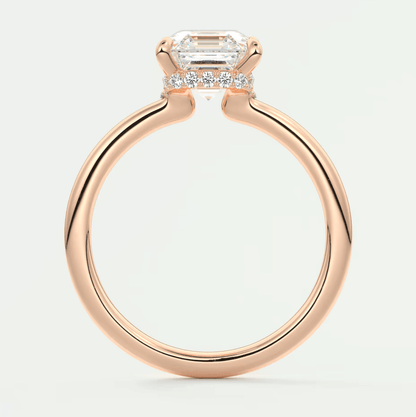 Rose gold emerald-cut diamond engagement ring with baguette accents and a sleek, modern design.