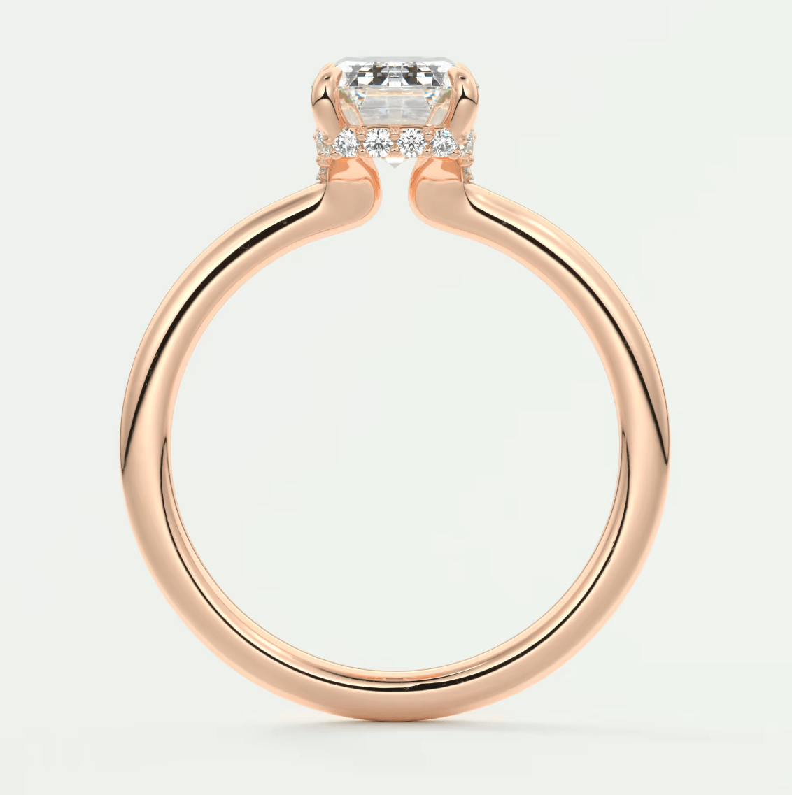 18-karat rose gold engagement ring with a cushion-cut diamond and halo of smaller diamonds.
