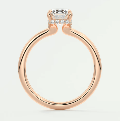18-karat rose gold engagement ring with a cushion-cut diamond and halo of smaller diamonds.