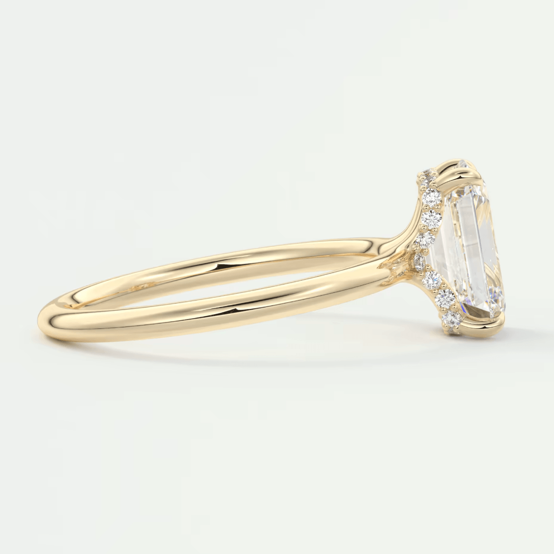 18k yellow gold emerald-cut diamond engagement ring with side diamonds.