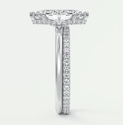 18-karat white gold diamond engagement ring with a cushion-cut center stone and pavé set diamonds on the band.