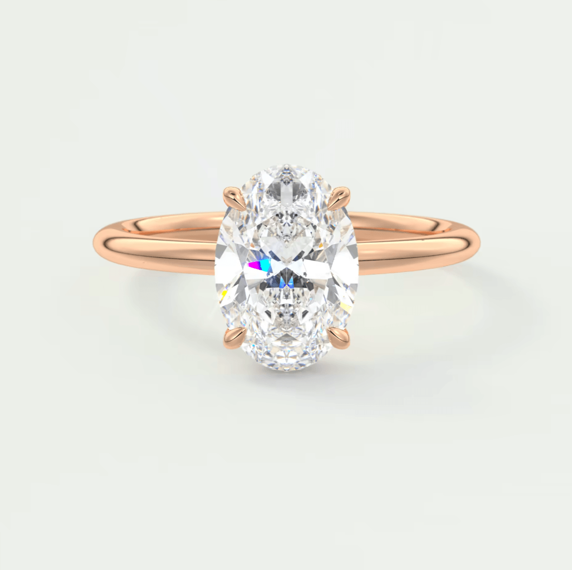 18k rose gold oval diamond engagement ring with a princess cut center stone.
