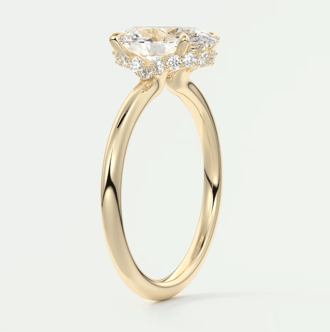 18k yellow gold engagement ring with a cushion-cut diamond and halo of smaller diamonds.