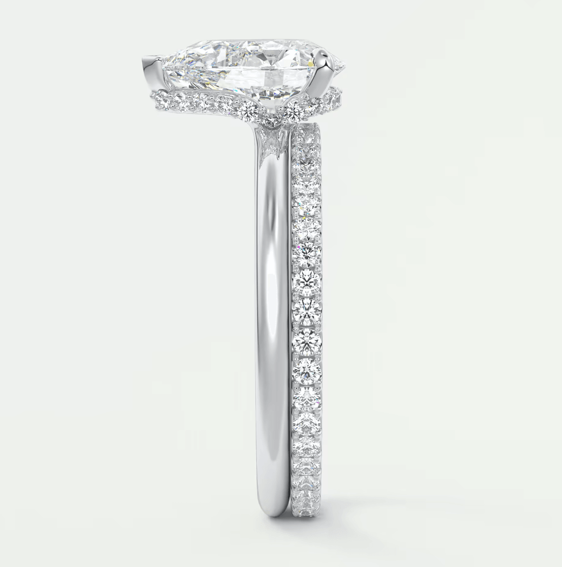18-karat white gold engagement ring with a cushion-cut diamond center stone and pavé-set diamonds on the band.