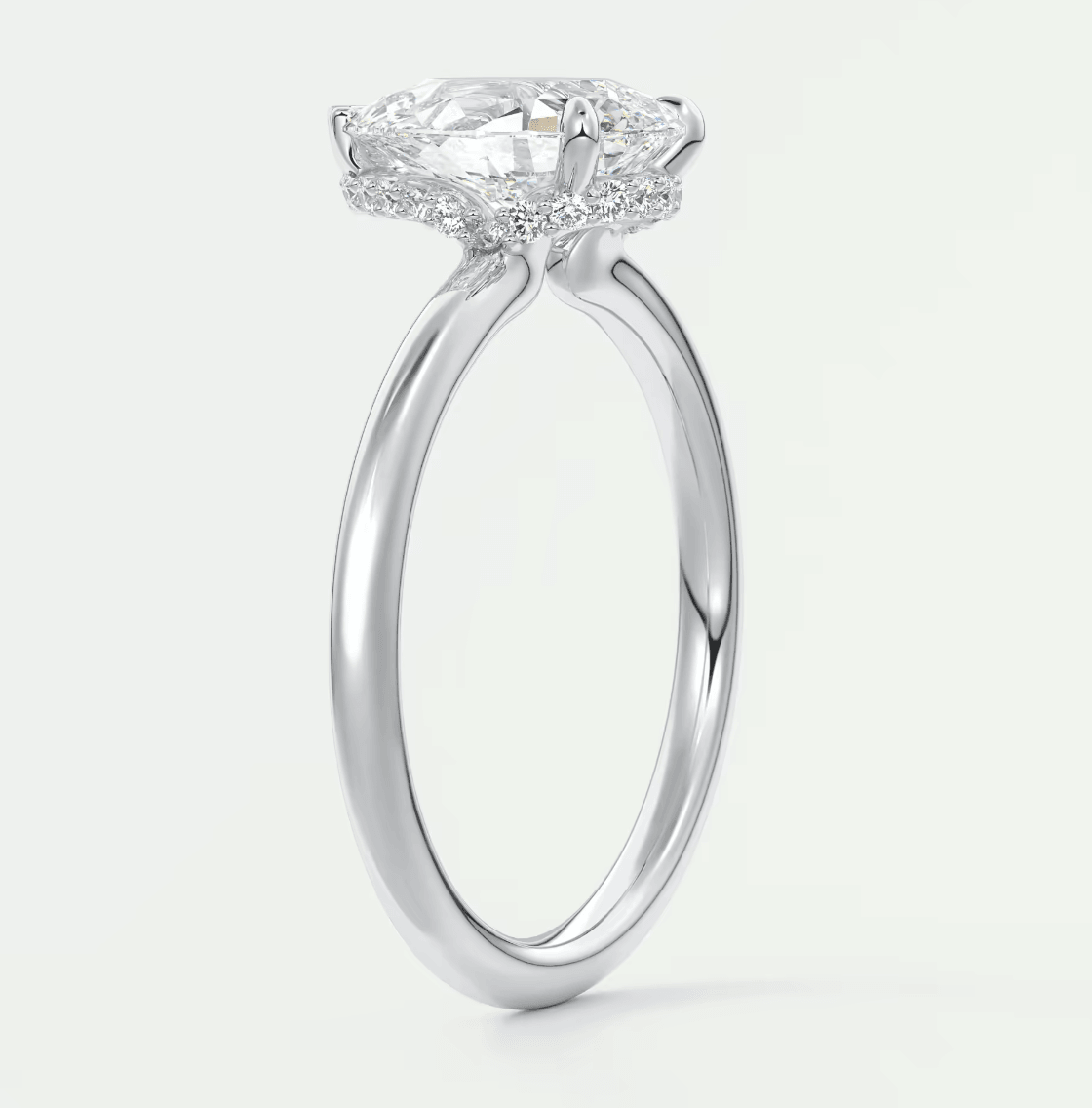 18-karat white gold engagement ring with a cushion-cut diamond center stone and halo of smaller diamonds.