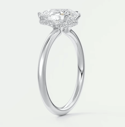 18-karat white gold engagement ring with a cushion-cut diamond center stone and halo of smaller diamonds.