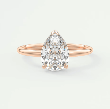 Rose gold pear-shaped diamond engagement ring with a solitaire design.