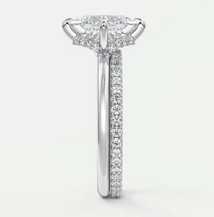 18k white gold diamond engagement ring with a marquise-cut center stone and pavé set diamonds on the band.