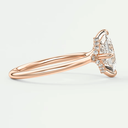 18-karat rose gold engagement ring with a marquise-cut diamond and small round diamonds set in the band.