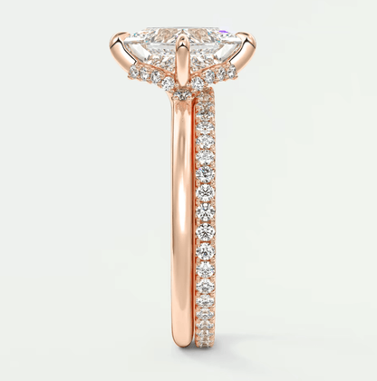 Rose gold diamond engagement ring with a marquise-shaped center stone and pavé set diamonds on the band.