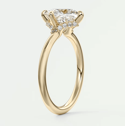 18k yellow gold engagement ring with a princess cut diamond and halo design.
