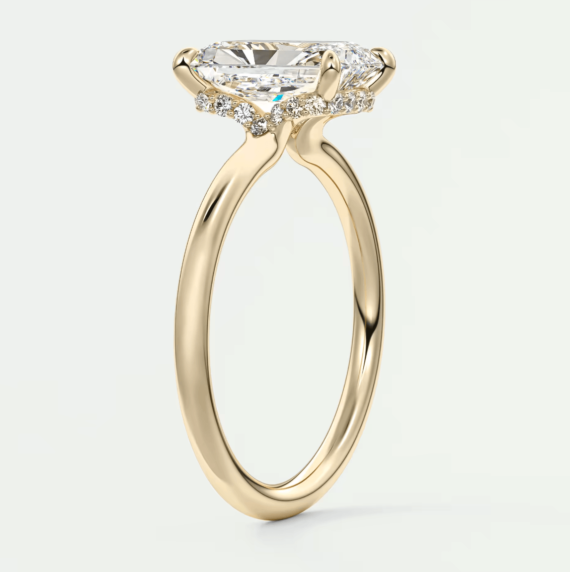 18k yellow gold engagement ring with a marquise-cut diamond and halo of smaller diamonds.