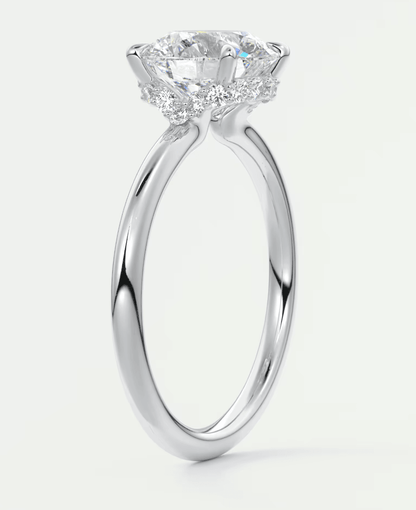 18-karat white gold engagement ring with a round diamond center stone.
