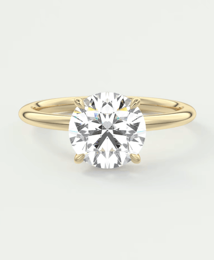 18-karat yellow gold solitaire diamond engagement ring with a round brilliant cut gemstone.