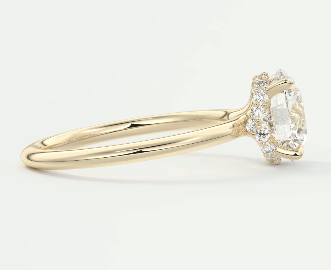 18k yellow gold diamond engagement ring with a marquise-cut center stone and halo of smaller diamonds.