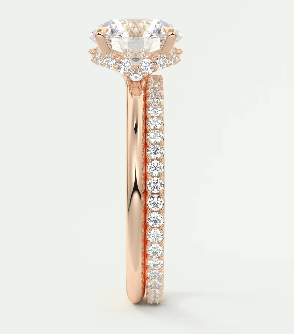 18k rose gold engagement ring with a cushion-cut diamond and pavé side stones.