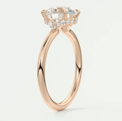 Rose gold diamond engagement ring with a cushion-cut center stone and small side diamonds.