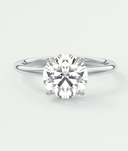 18-karat white gold solitaire diamond engagement ring with a cushion-cut center stone.